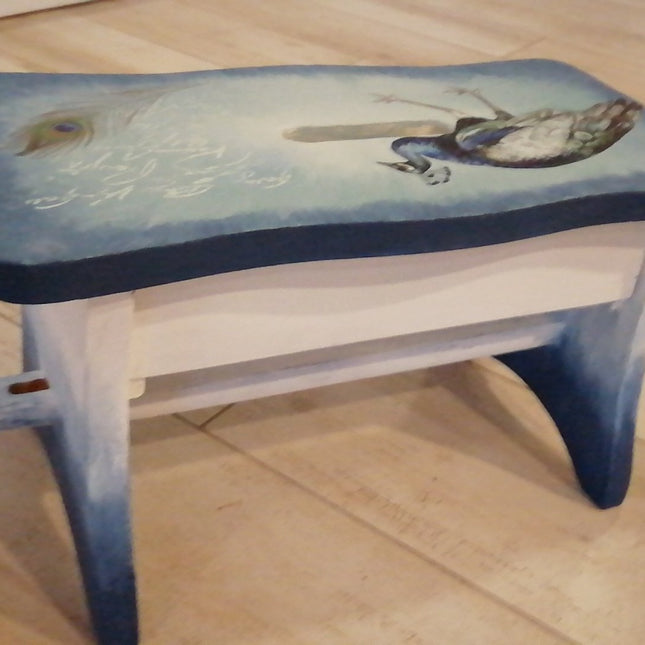 Kleiner gestrichener Hocker mit einem Pfauenmotiv in blau weiß.
