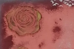 Detailaufnahme einer Rose die mit Modelliermasse geformt und mit Kreidefarbe und Goldwachs verziert wurde.
