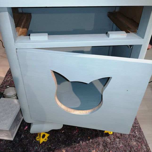 Nachtkasten mit einem ausgesägten Katzenkopf in der Tür als späterer Schlafplatz für die Katze