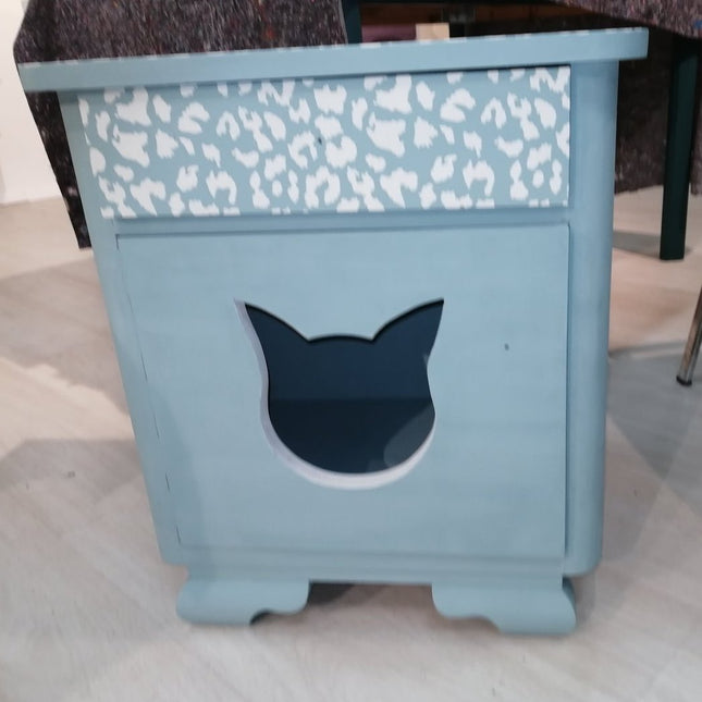 Nachtkasten mit einem ausgesägten Katzenkopf in der Tür als späterer Schlafplatz für die Katze in Rauchblau gestrichen.