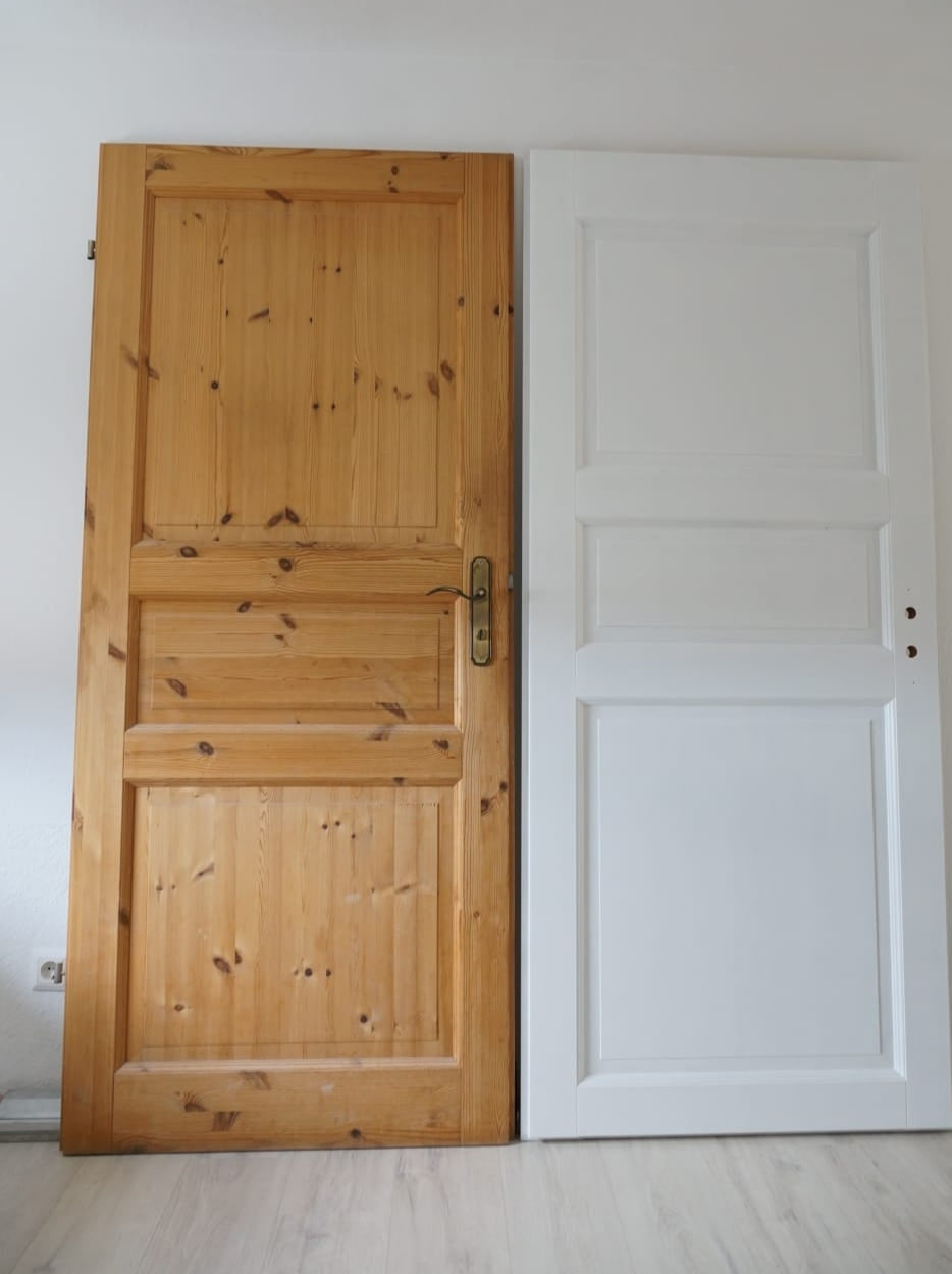 Eine Tür in Kiefer unbearbeitet und eine weiß gestrichene Tür