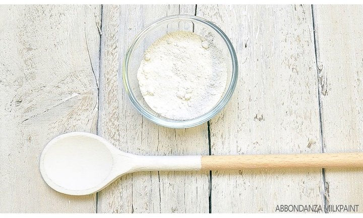 Eine Schüssel mit Milk Paint Pulver und ein Kochlöffel